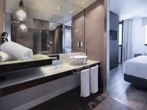 a bathroom with a sink and a large mirror at Hotel Barcelona Condal Mar Affiliated by Meliá in Barcelona +70 photos
