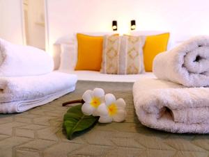 Una habitación con toallas y una flor en el suelo. en Casa El Drago 6, en Breña Baja