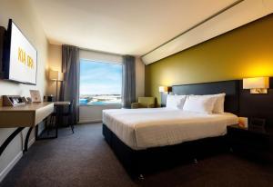 a hotel room with a large bed and a window at Sudima Auckland Airport in Auckland