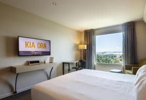 a hotel room with a large bed and a window at Sudima Auckland Airport in Auckland