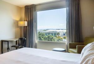 a hotel room with a bed and a window at Sudima Auckland Airport in Auckland