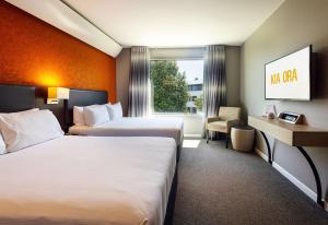 a hotel room with two beds and a window at Sudima Auckland Airport in Auckland
