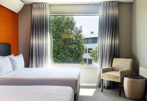 a hotel room with a bed and a window at Sudima Auckland Airport in Auckland