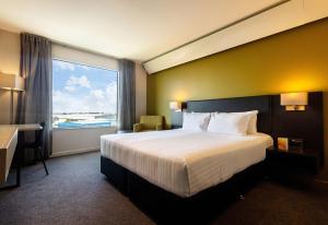 a hotel room with a bed and a large window at Sudima Auckland Airport in Auckland