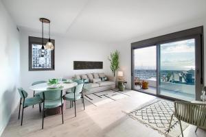 Una sala de estar con una mesa y sillas y un sofá. en Seaside Badalona Apartment, en Badalona
