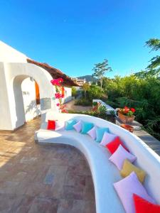a white bench with colorful pillows on a patio at il poggio in Ischia