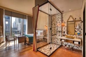 a hotel room with a bathroom with a bed and a shower at 25hours Hotel Dubai One Central in Dubai