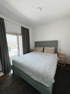a bedroom with a large bed and a window at 3 Br Penthouse Jacuzzi Seaview in Limassol