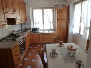 a kitchen with wooden cabinets and a table with cups on it at Appartamento Sole in Borca di Cadore