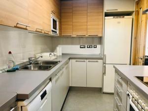 a kitchen with white cabinets and a sink and a refrigerator at HABITACION ROOM Larga Temporada MAS DE 60 DIAS MALAGA CENTRO in Málaga