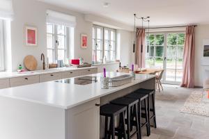 a kitchen with a large island with black stools at Storchennest in Wyk auf Föhr