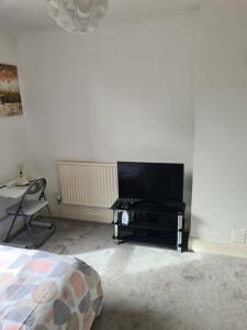 a bedroom with a flat screen tv and a bed at A private & beautiful bedroom with shared bathroom in the heart of Bournemouth in Bournemouth +17 photos