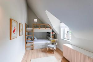 a room with a bunk bed and a chair at Storchennest in Wyk auf Föhr