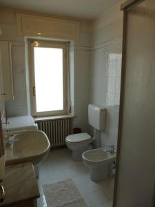 baño con lavabo y aseo y ventana en Appartamento Sole, en Borca di Cadore