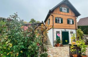 a small house with a green door in a garden at Blütenstöckl in Frutten +54 photos