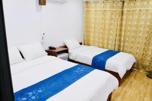 a room with two beds and a window at Agarwood in Hanoi +9 photos