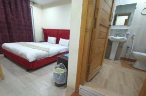 um quarto com uma cama e um banheiro com uma pia em Mount View Hotel Skardu em Skardu