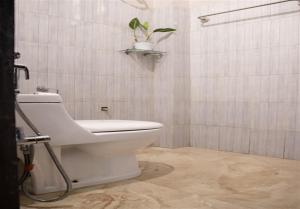 a bathroom with a toilet and a plant on a shelf at Akim Homestay in Kohīma