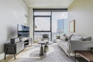 Una sala de estar con un sofá y una ventana grande. en Blueground West Loop pool gym spa wd elev CHI-1099, en Chicago