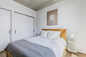 1 dormitorio blanco con 1 cama con cabecero de madera en Blueground West Loop pool gym spa wd elev CHI-1099, en Chicago 31 fotos más