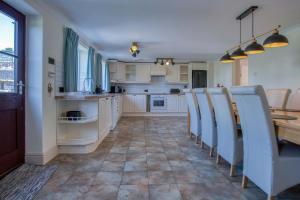 a kitchen with a table and chairs in it at The Cross - 4 Bedroom Cottage - Llangennith in Llangennith