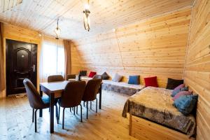 a room with a couch and a table and chairs at Cottage Caucasus in Ushguli