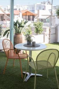 a table and two chairs on a balcony with plants at GeoFan Penthouse I in Athens