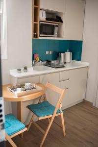 a small kitchen with a table and a microwave at GeoFan Penthouse I in Athens +14 photos