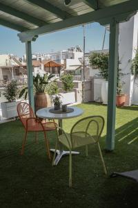 a patio with two chairs and a table on a roof at GeoFan Penthouse I in Athens