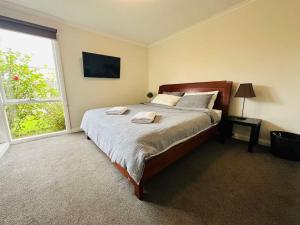 Un dormitorio con una cama grande y una ventana. en Serene Retreat Ideal Escape, en Edithvale 3 fotos más