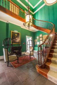 a staircase in a room with green walls at Solar dos Cantos Botanic House & Garden in Ponta Delgada