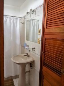 a white bathroom with a sink and a mirror at Vistas in Piriápolis