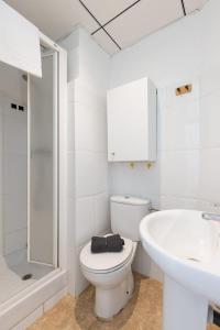 a white bathroom with a toilet and a sink at Rovellat by Unik Vacation in Tarragona