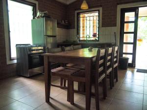 a kitchen with a wooden table with chairs and a refrigerator at MyFarm - Nema Kunku - An Educational Centre in Ker Dobaly +14 photos