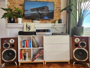 a living room with a white entertainment center with speakers at Apartamenty pod Aniołami in Ostrów Wielkopolski