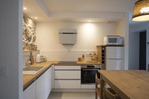 una cucina con elettrodomestici bianchi e tavolo in legno di Appartement de charme - La Tour a La Tour