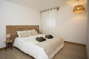 una camera da letto con un letto grande con due asciugamani sopra di Appartement de charme - La Tour a La Tour