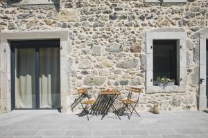 un tavolo e sedie di fronte a un edificio in pietra di Appartement de charme - La Tour a La Tour