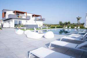 a villa with a swimming pool and lounge chairs at Villa Luxury Eden di Sofia in Partinico