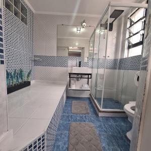 a bathroom with a shower and a toilet at Frente Mar Santos 130 m2 in Santos +33 photos