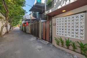 a walkway next to a building with a fence at N to M Cozy House - near the my khê beach - dragon bridge - center in Da Nang