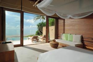 a bedroom with a bed and a view of the ocean at Six Senses Con Dao - Turtle Island Paradise in Con Dao