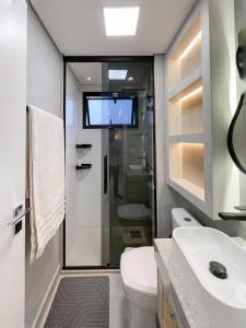 ein Bad mit einem WC und einem Waschbecken sowie einen TV in der Unterkunft Luxury Collection - Flat Ultra Luxo com 2 quartos in Campo Grande + 22 Fotos