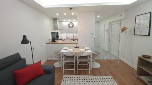 a kitchen and living room with a table and chairs at Bambusz Apartman with parking in Budapest