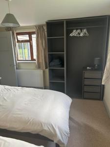 a bedroom with a white bed and a closet at Cottage Retreat- Sleeps 4 Garden in Sherborne +23 photos