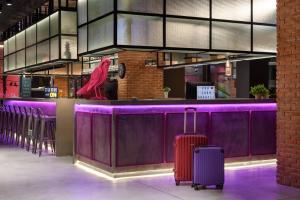 a purple bar with two suitcases in front of it at Moxy Lisbon City in Lisbon