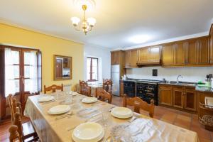 a dining room with a table and a kitchen at Zelaikoa Goikoa - baskeyrentals in Zestoa