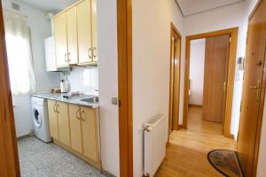 eine Küche mit weißen Schränken und einer Spüle und einer Tür in der Unterkunft Cuencaloft La Casa de Fernando in Cuenca + 11 Fotos