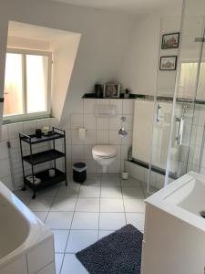 a white bathroom with a toilet and a shower at Zentrale Altbauwohnung mit Flair in Schwäbisch Hall