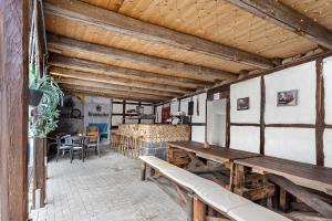 a patio with wooden benches and a table at Gruppenhaus Osterhagen in Bad Lauterberg